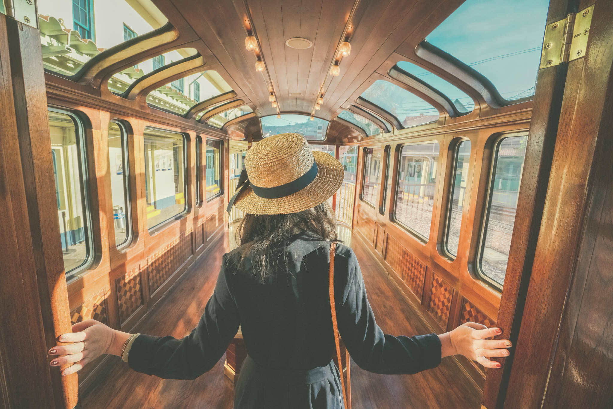 A traveller in a vintage rail carriage, arms wide